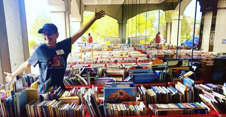 A Library volunteer with donated books at one of the Friends book sales